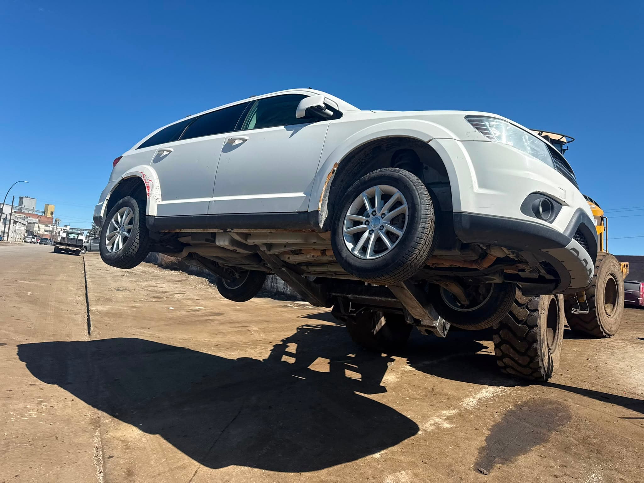 White SUV lifted for junk car collection in Calgary